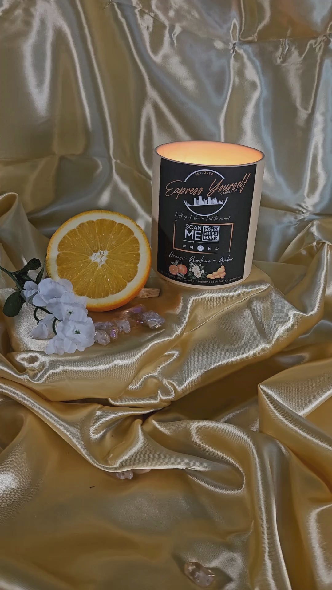 Handmade Orange, Gardenia, Amber luxury coconut apricot wax candle with QR code label on gold surface.