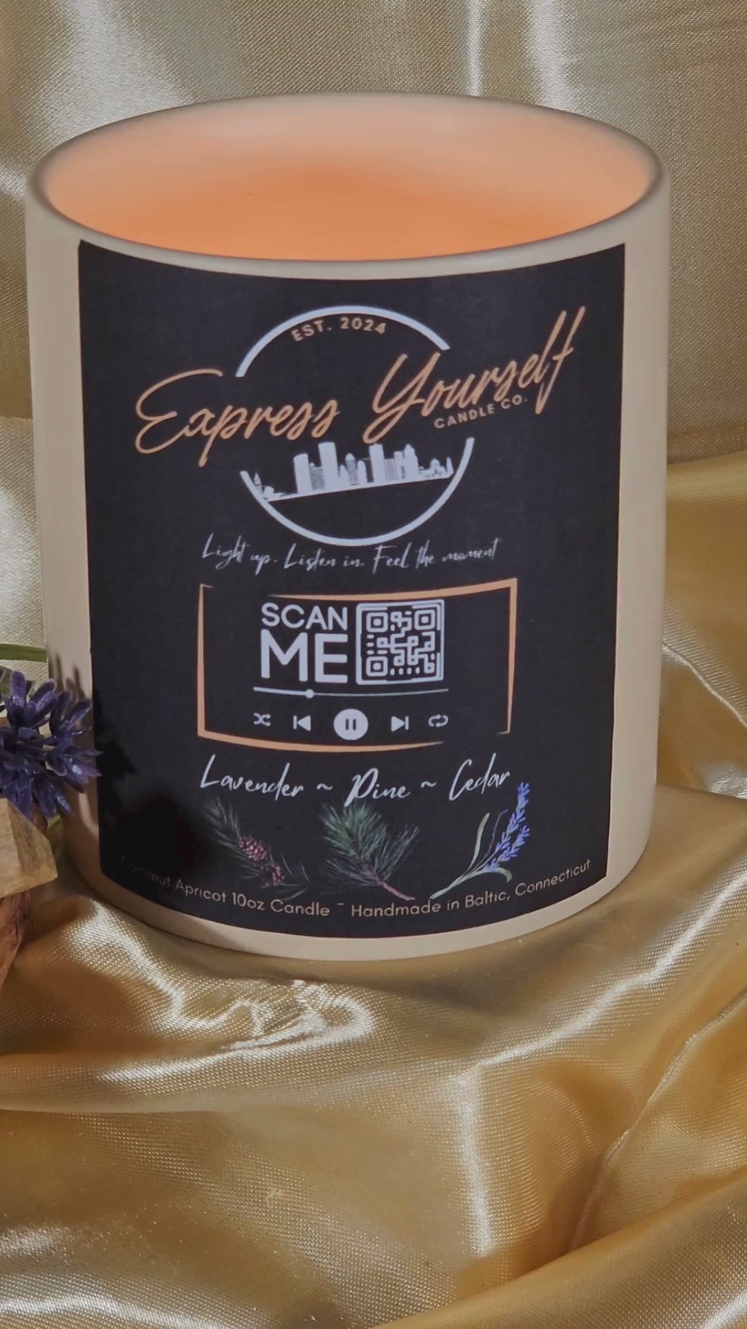 Handmade lavender, Pine, Cedar luxury coconut apricot wax candle with QR code label on gold surface.